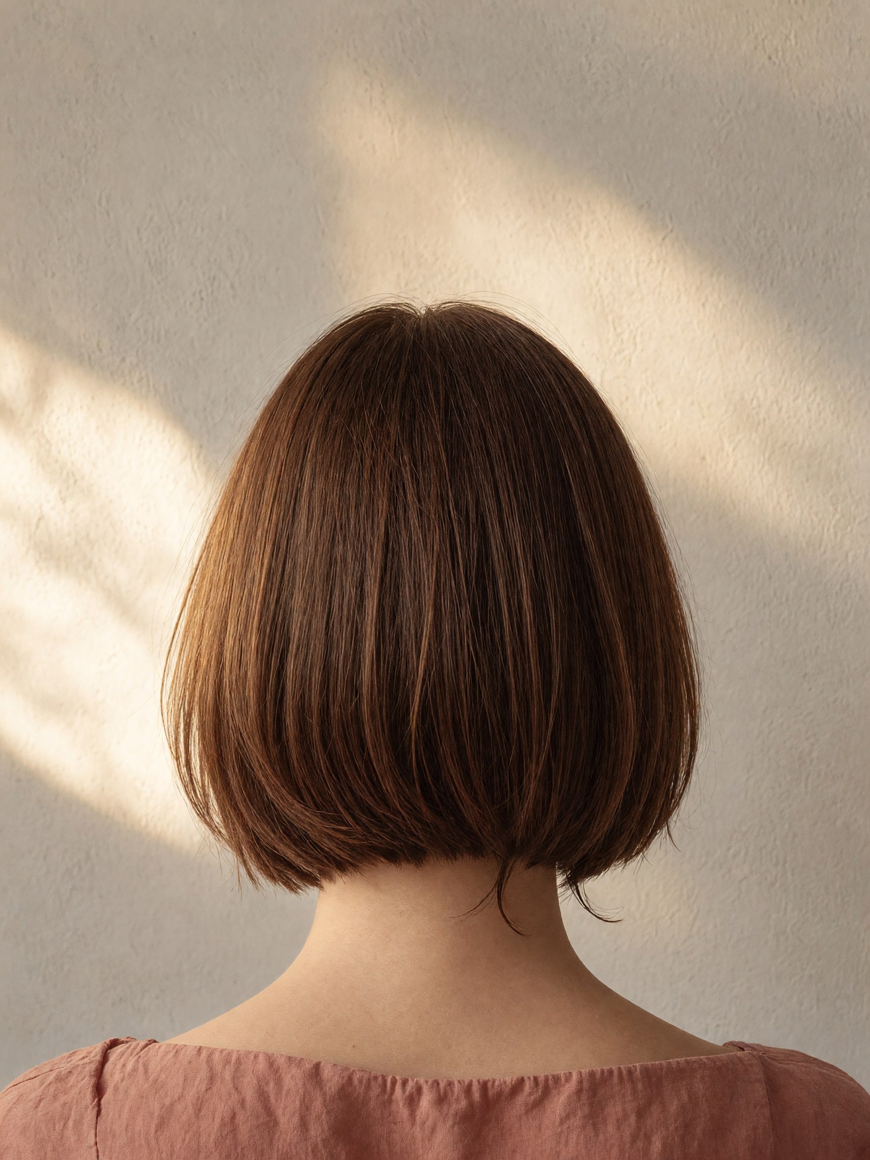 A freshly cut chestnut bob, seen from the back.